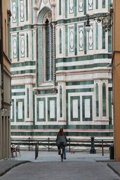 A girl rides her bike, discovering the Cattedrale of Santa Maria del Fiore in Florence, Italy, as she gets closer. Captured by Photographer Scott Allen Wilson.