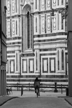 A photo of a Girl in Florence riding a bicycle towards the Duomo in Florence, Italy taken by Photographer Scott Allen Wilson.