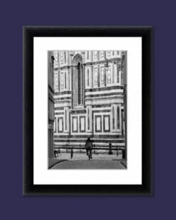 A black and white photo of a Girl in Florence riding a bicycle towards the Duomo in Florence, Italy taken by Photographer Scott Allen Wilson.