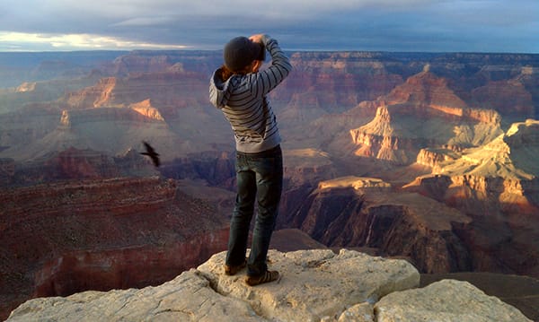 Portrait of photographer Scott Allen Wilson taking a landscape photograph looking over the grand canyon at sunset