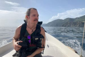 Portrait of photographer Scott Allen Wilson during a shoot on a private boat in Cinque Terre, Italy