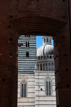 Artistic photo of the Cathedral of Siena, Italy, peaking out behind a brick arch taken by Photographer Scott Allen Wilson.