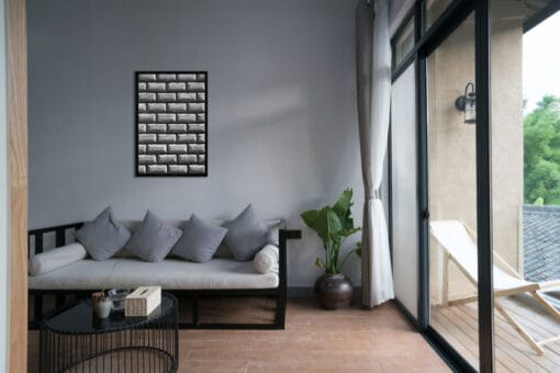 Gray living room decoration with a black framed print of the brick structure of Palazzo Orsini in Naples, Italy.