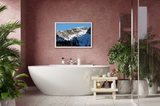 Modern bathroom design with a pink wall and a print of a jagged mountain of the Dolomites, Italy covered in snow and with a light blue sky in the background taken by Photographer Scott Allen Wilson.