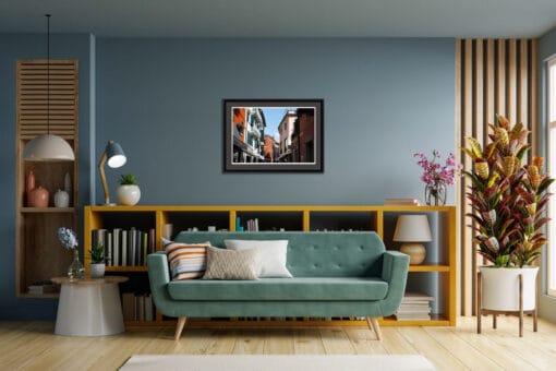 Cozy living room decoration with a blue wall and a framed photo of the colorful buildings in Peschiera del Garda, Italy taken by Photographer Scott Allen Wilson.