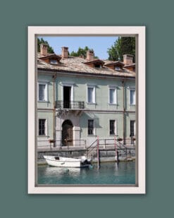 White framed print of a traditional building at the edge of the water taken in Peschiera del Garda, Italy by Photographer Scott Allen Wilson.