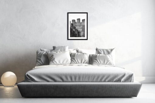 Minimalist gray bedroom decoration with a black and white framed print showing the different angles and geometric shapes of Castello Scagliero di Lazise in Italy taken by Photographer Scott Allen Wilson.