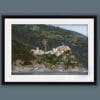 Black framed artistic print of the town of Corniglia in Cinque Terre, Italy, on a green hill. By Photographer Scott Allen Wilson.