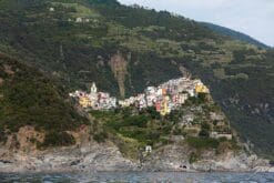 The colorful town of Corniglia in Cinque Terre, Italy, is nestled in a green hill. By Photographer Scott Allen Wilson.