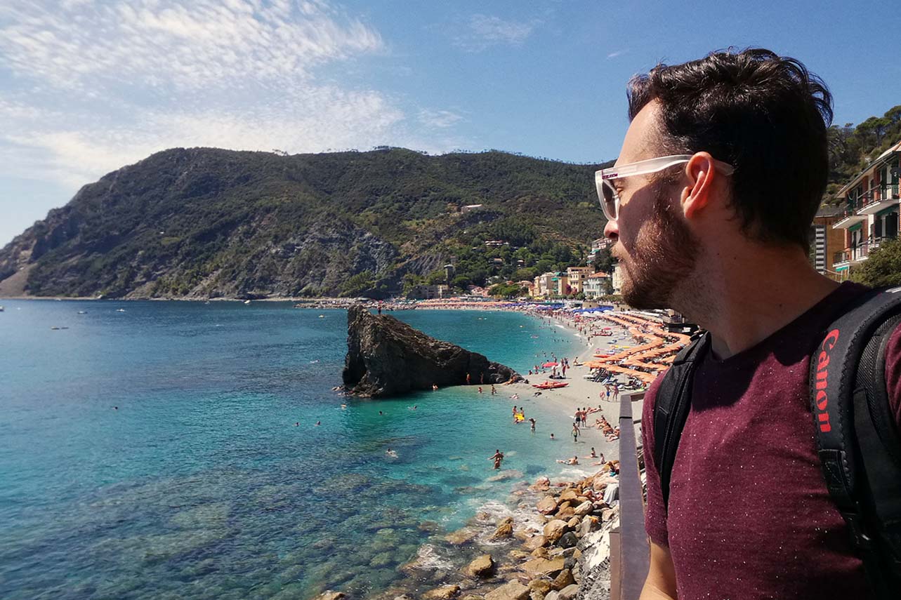 Photographer Scott Allen Wilson looks up on the clear blue water and beach scene in Monterosso al Mare, Italy