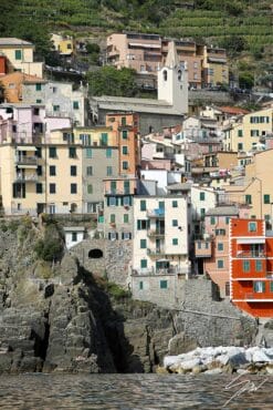 Colorful houses of Rio Maggiore, Cinque Terre, Italy, with vineyards above and sea beneath. By Photographer Scott Allen Wilson.