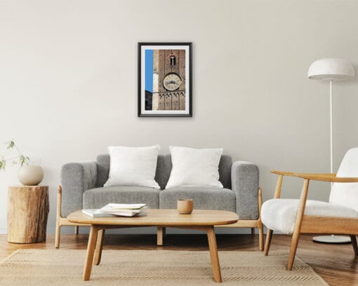 A print of the clock tower of Parma hung in a beige minimal room with wooden decor. By Photographer Scott Allen Wilson.