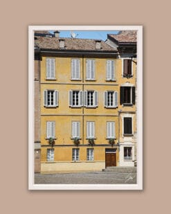 White framed print of a big yellow building with lots of windows in Parma. Created by Photographer Scott Allen Wilson