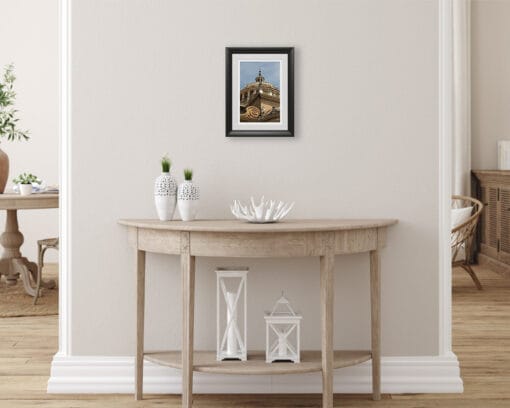 A print of the Basilica of Parma hung in a beige room with wooden decor. By Photographer Scott Allen Wilson.