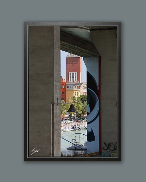 A black framed print of a square with a clock tower in Pescara, Italy. By Photographer Scott Allen Wilson.