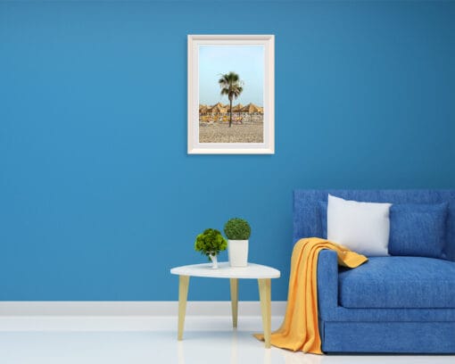 A white framed print of a beach in Pescara, Italy hanging in a room with bright colored decor. By Photographer Scott Allen Wilson.