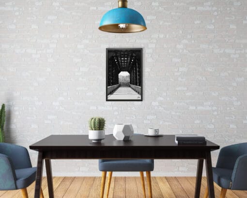 A black framed print of an iron bridge in Pescara, Italy, hanging in an industrial style kitchen. By Photographer Scott Allen Wilson.