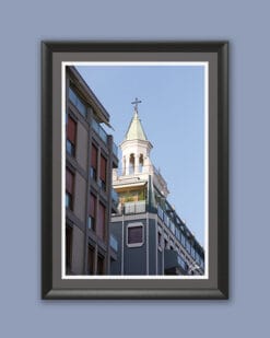 A black framed print of a clock tower in Pescara, Italy, standing out behind modern buildings. By Photographer Scott Allen Wilson.