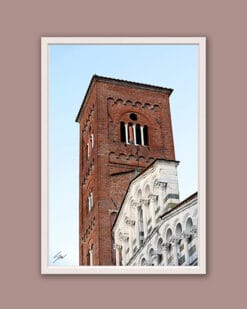 A white framed print of the San Francesco Church in white and green marble, while a red brick tower stands behind it in the city of Lucca, Italy. By Photographer Scott Allen Wilson.