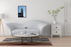 A black framed print of San Michele in Foro in Lucca, Italy, hanging in a minimal living room with white furniture. By Photographer Scott Allen Wilson.