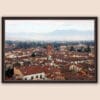 A dark brown framed print of a view of the city of Lucca, Italy. By Photographer Scott Allen Wilson.