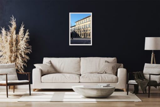 A white framed print of an old noble palace in Lucca, Italy, hanging in a modern living room with minimal white decor. By Photographer Scott Allen Wilson.