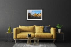 A black framed print of piazza dell’anfiteatro in Lucca, Italy, hanging in an edgy living room. By Photographer Scott Allen Wilson.