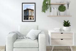 A black framed print of shadows playing on a building in Lucca, Italy, hanging in a white minimal living room. By Photographer Scott Allen Wilson.