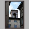 A dark brown framed print of a bell tower in the city of Lucca, Italy. By Photographer Scott Allen Wilson.