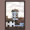 A dark brown framed print of a bell tower and red tiled rooftops in the city of Lucca, Italy. By Photographer Scott Allen Wilson.