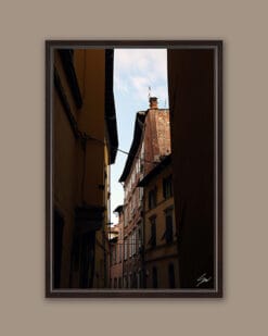 A dark brown framed print of rooftops in Lucca, Italy. By Photographer Scott Allen Wilson.