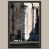 A dark brown framed print of a view of the city of Lucca where an old man is taking a stroll, Italy. By Photographer Scott Allen Wilson.