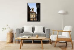 A framed print of an elegant palace in Torino, Italy, hanging in a living room with natural wooden decor