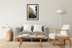 A black framed print of Torino's city center, Italy, hanging in a minimal living room with wooden furniture. By Photographer Scott Allen WIlson.