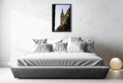 A black framed print of a tower in Turin, Italy, hanging in a minimal bedroom. By Photographer Scott Allen Wilson.