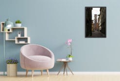 A black framed print of a bell tower in Torino, Italy, hanging in a modern living room with light toned decor. By Photographer Scott Allen Wilson.