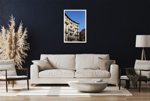 A white framed print of a palace hit by light and shadow in Torino, Italy, hanging in a dark toned living room. By Photographer Scott Allen Wilson.