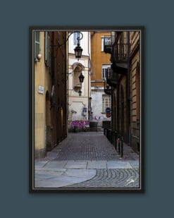 A black framed print of a cobblestone street in Torino, Italy. By Photographer Scott Allen Wilson.