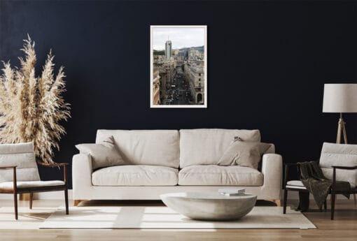 The bright and illuminated buildings, crossed by a darker colored street, balance the navy blue walls and the cream decors of this living room in the most excellent way.