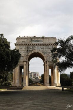 A wonderful warm toned arch stands between verdant trees. With its adorned stone, it tells stories of the past, while golden sunbeams light up its majestic columns.