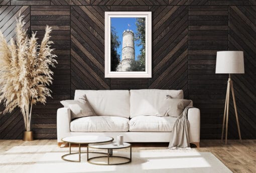 Hanging in the middle of this dark wooden living room is the eye-catching white framed stone tower of Genova, creating a striking contrast between the brown walls and the bright stone bricks. Even the furnishings contribute to giving more luminosity to the dim room.