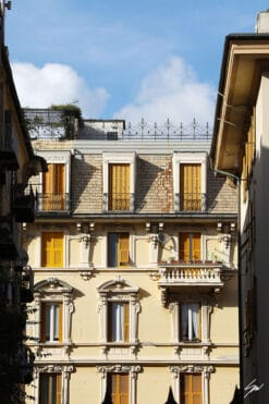 A cream colored residential house, brightly lit and richly decorated, stands proud between two more structures. Photo captured by Travel Photographer Scott Allen Wilson.