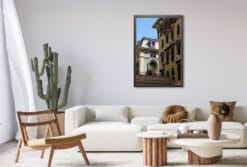 The brightly lit and painted room accentuates the shadows emerging from the photo. The yellow wall stands in the dark before the illuminated one, creating a feeling of depth within this living room.