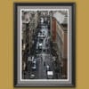 Wooden framed artistic print of a detailed urban scenery in Genova, Italy, featuring a bustling street enclosed by tall and elegant buildings. Photo captured by Travel Photographer Scott Allen Wilson.