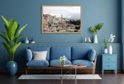 The softly lit structures, rising beneath a faded grey sky, compliment the deeper blues of this cool toned living room.