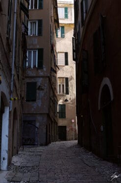 Old cobblestone path stretches between time-worn residential blocks. Photo captured by Travel Photographer Scott Allen Wilson.