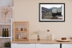 Travel Photographer Scott Allen Wilson’s artwork, surrounded by a black frame and white passe-partout, is displayed on the kitchen wall of this minimalistic room. Filled with cool tones, it perfectly contrasts the warm tones of the ambiance.