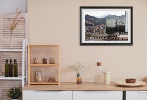 Travel Photographer Scott Allen Wilson’s artwork, surrounded by a black frame and white passe-partout, is displayed on the kitchen wall of this minimalistic room. Filled with cool tones, it perfectly contrasts the warm tones of the ambiance.