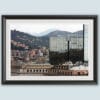 A black frame with a white passe-partout surrounds a work of art created by Travel Photographer Scott Allen Wilson. The subject is a landscape of Genova, Italy, which focuses on a mix of historical buildings, and a reflective modern skyscraper as well.