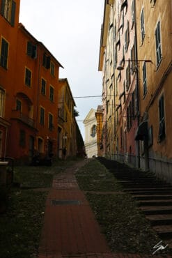 A wide palette of earthy colors unfolds within this shot, where an old alley unwinds uphill between towering structures. Photo captured by Travel Photographer Scott Allen Wilson.